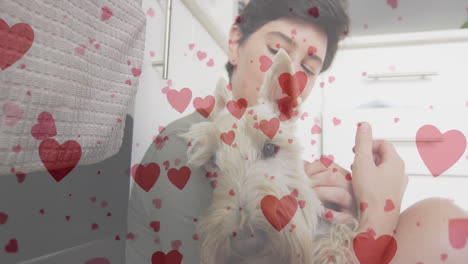 animación de emojis de corazón sobre feliz mujer caucásica con perro
