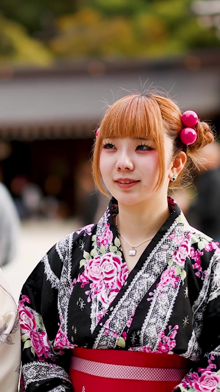 Giovani donne giapponesi che indossano kimono floreali stanno insieme all'aperto al Santuario Meiji a Tokyo