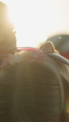 a woman lies back on a bike, adjusting her sunglasses while small insects fly around her face, the sunlight creates a soft glow
