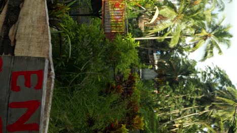 Slow-motion-tilt-up-shot-in-front-of-the-entrance-of-tegallalang-rice-terraces-on-bali-in-indonesia-with-the-signs-from-the-entrance-for-hiking-and-tracking