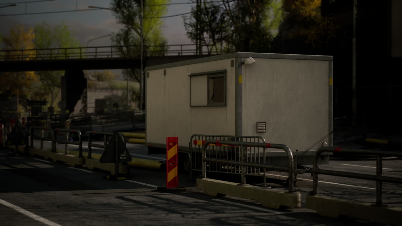 Temporary construction site office with barriers near busy road