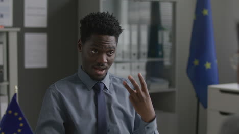 black consular officer explaining eu visa application process to man