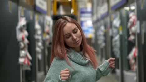 Portrait-of-a-woman-dances-in-hardware-store-between-the-rows