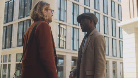 Black-Businessman-Shaking-Hands-and-Talking-with-Colleague-Outdoors