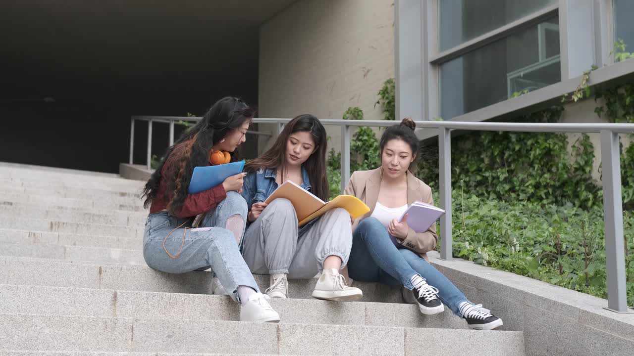 three asian girl students talking at break time sitting on campus