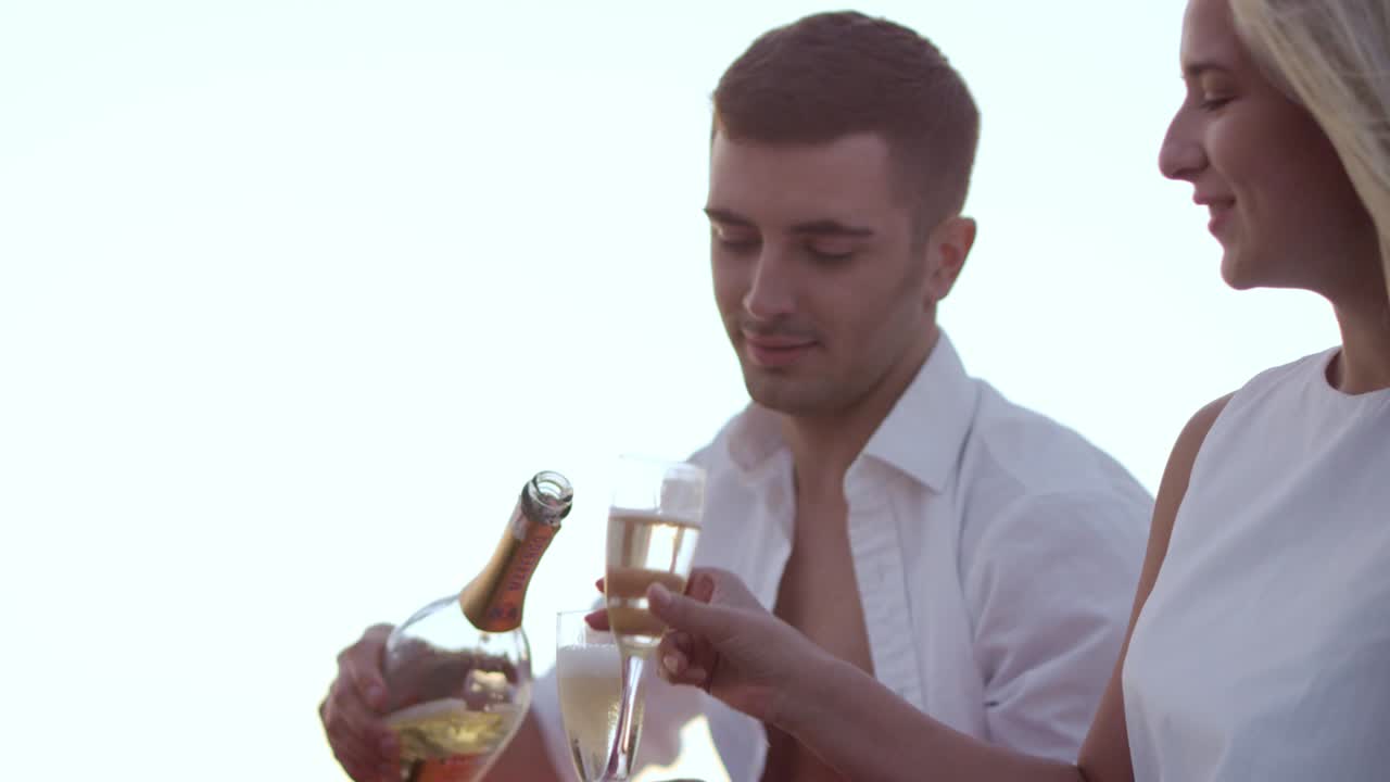 una joven pareja bebiendo vino al atardecer. novio y novia enamorados