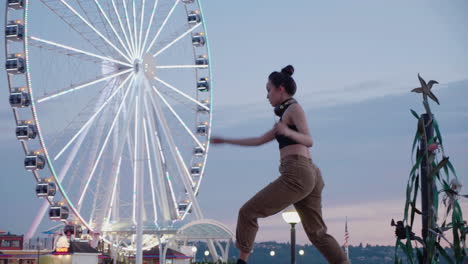 Young,-female,-contemporary-dancer-near-an-urban-Ferris-wheel