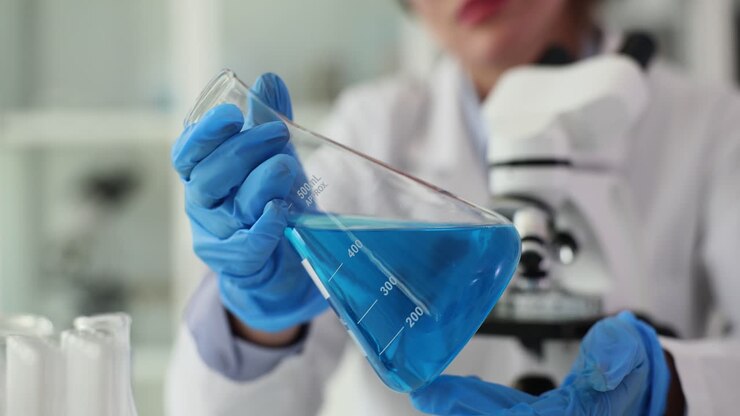 Scienziato che tiene in mano un becher con liquido blu in laboratorio