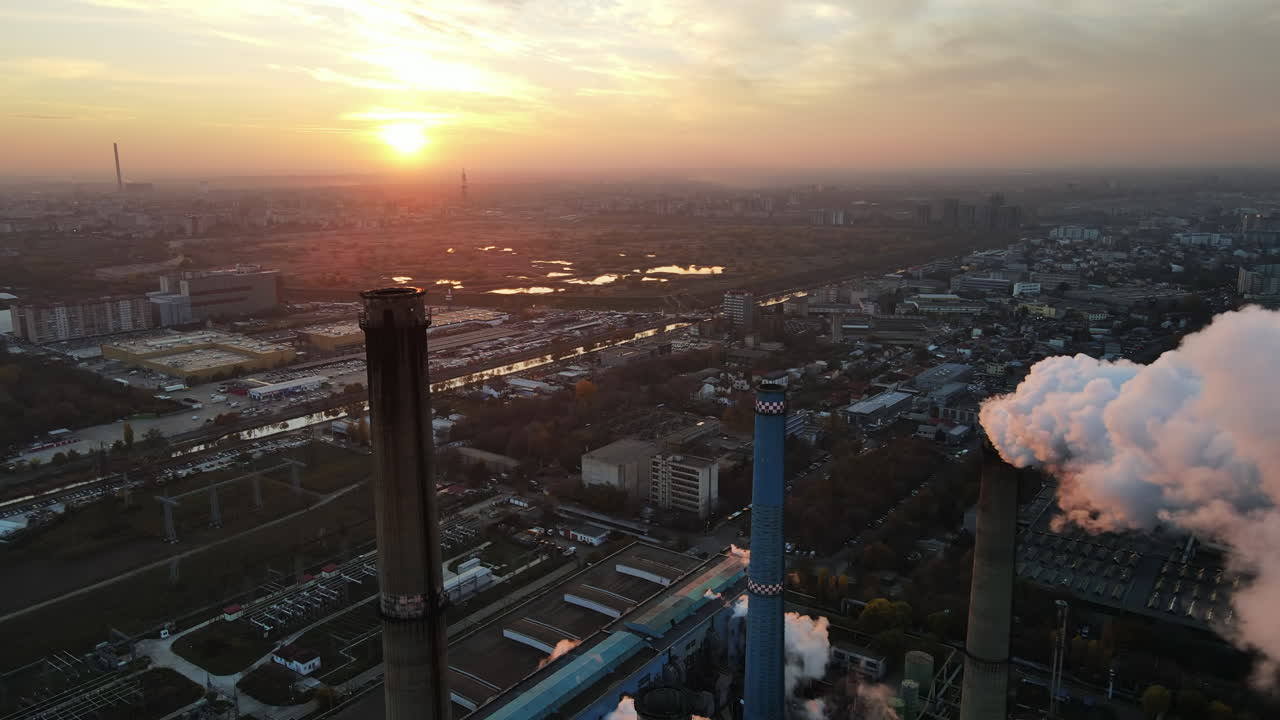 Power station with a lot of tubes and facilities in Bucharest at sunset, a lot of foam from inside a tube. Cityscape, view from the drone flying through the foam, Romania