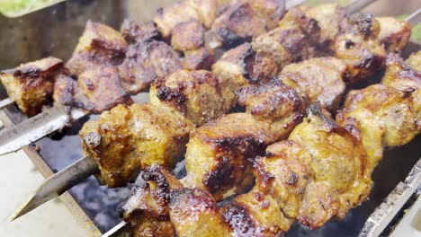 the cook prepares barbecue from pork meat the barbecue is spinning on an open fire the cook prepares barbecue from pork meat the barbecue is spinning on an open fire close up