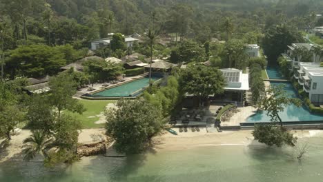 aerial drone shot low angle of a tropical beach tourist destination in thailand with no tourists due to travel restrictions and shut downs with empty hotels and empty beaches