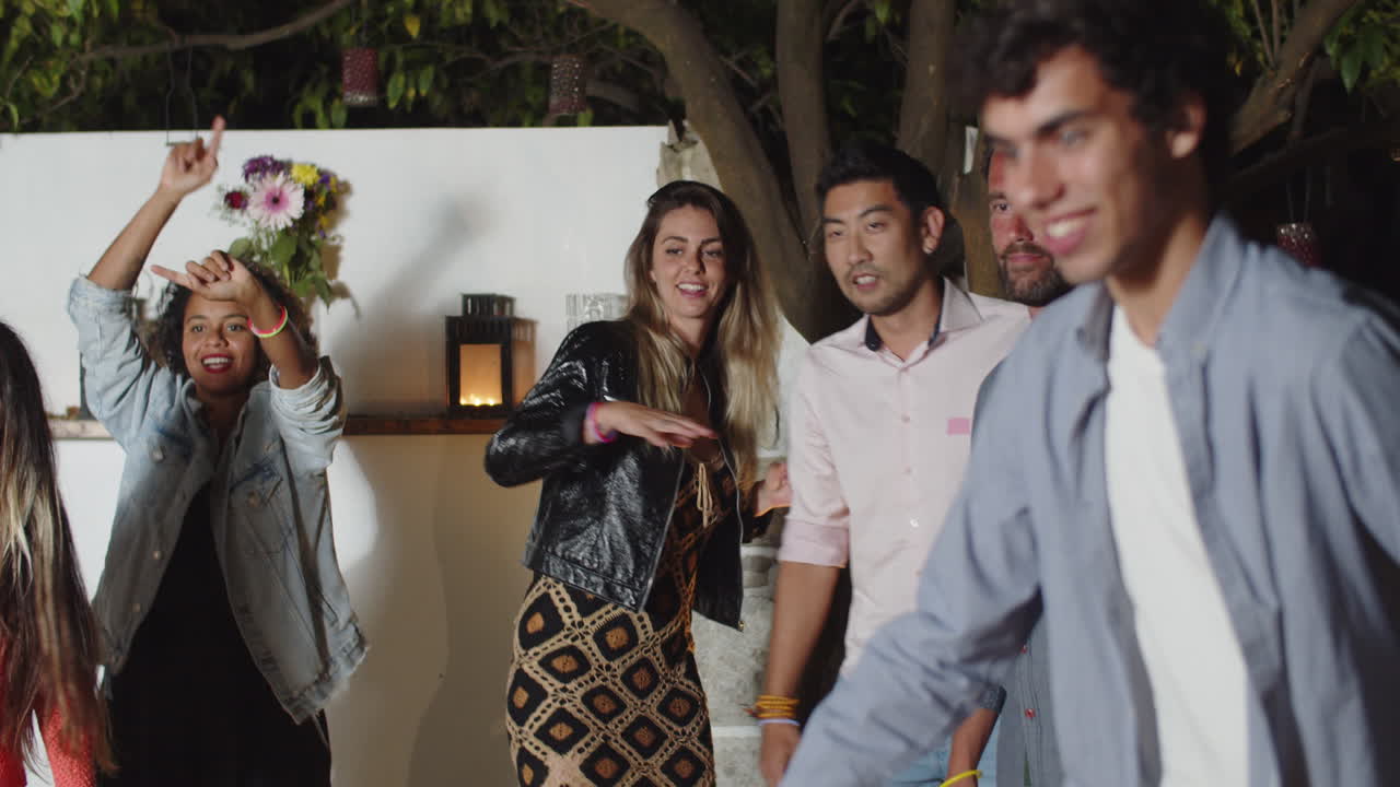 grupo diverso de personas felices bailando en la corte en la fiesta nocturna