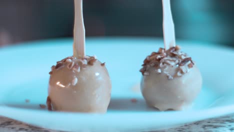 decorating cake pops with nuts in a table