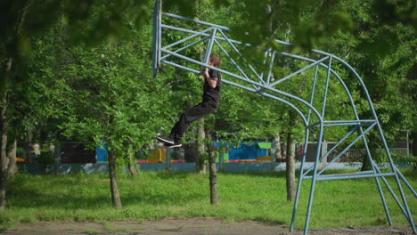 a young boy dressed in a black outfit performs multiple pull-ups, gradually lifting his head over the bar on outdoor equipment, with lush green trees and fence in the background