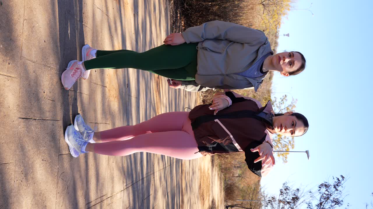 las corredoras discuten la ruta para la sesión de carrera usando un reloj inteligente. vertical