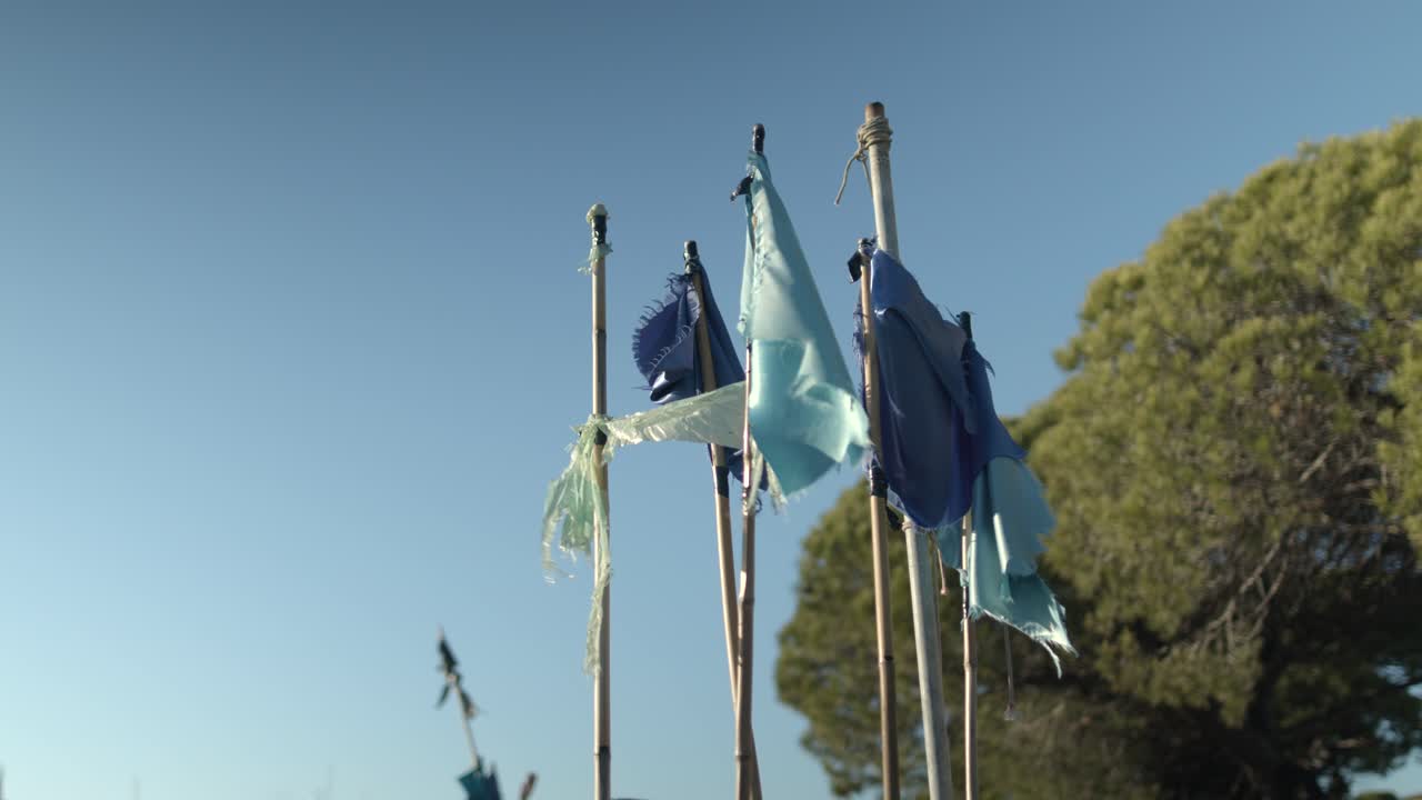 나무 한 그루를 배경으로 바람과 함께 움직이는 낡고 망가진 어선 깃발