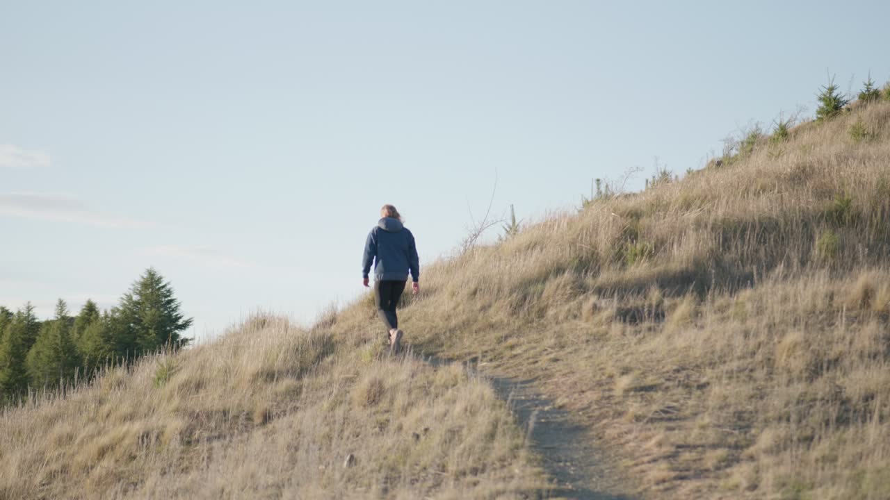 Ripresa a mano libera di un'escursionista solitaria che cammina lungo il sentiero della penisola di Benmore.