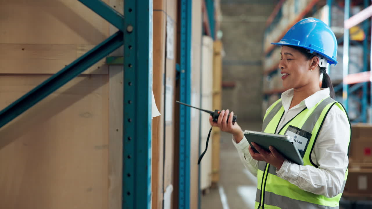 Warehouse worker with walkie talkie and tablet
