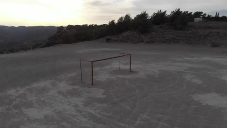 antena: disparo en órbita de un gol de fútbol vacío durante la puesta de sol en un campo duro