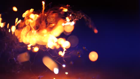 macro-of-steel-wool-getting-burned-on-blue-background-with-bokeh