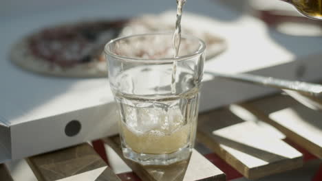 gros plan d'une personne méconnaissable qui verse de la bière dans du verre sur la table tout en faisant une fête en plein air