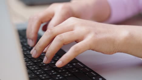 close up hand of a business woman typing keyboard laptop computer on desk office