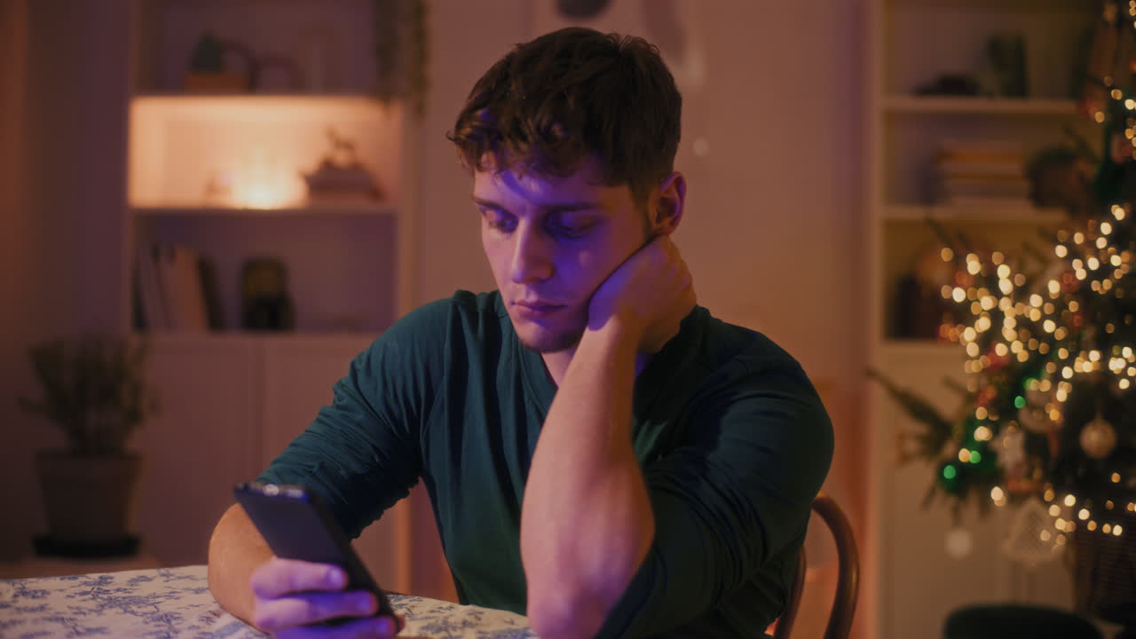 hombre usando teléfono inteligente mientras está sentado en la mesa