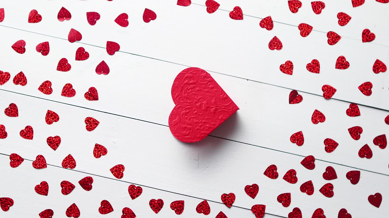 composición del día de vlentine lentejuelas en forma de corazón colocadas sobre una mesa de madera blanca