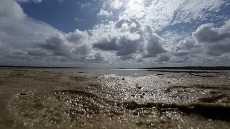 Beautiful-landscape-worms-eye-view-shot-of-a-tropical-wet-sand-bar-in-the-Guaraíras-Lagoon-of-Tibau-do-Sul,-Brazil-in-Rio-Grande-do-Norte-during-a-sunny-summer-cloudy-day-near-Pipa