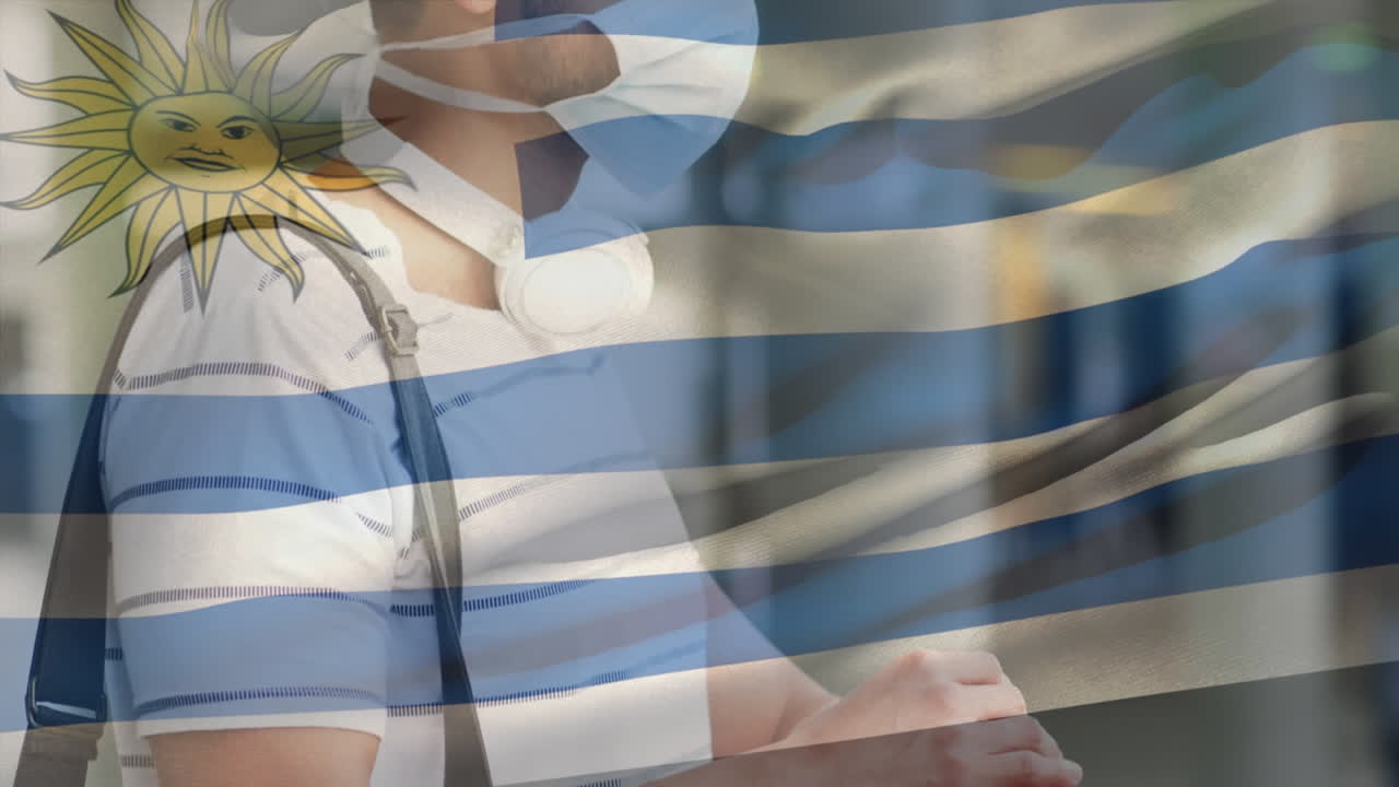 코로나 19 대유행 기간 동안 얼굴 마스크를 쓰고 있는 남성 위에 울려 퍼지는 우루과이 국기의 애니메이션