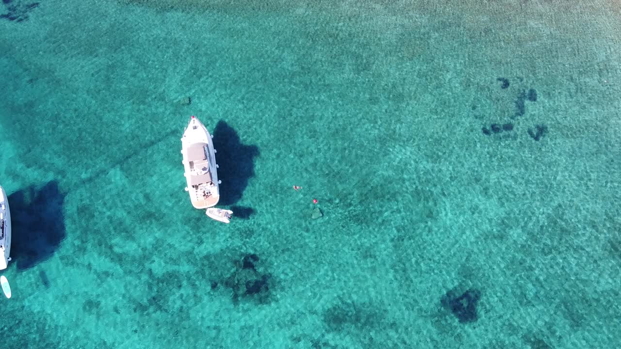Tourists swim in crystal clear water by yacht, Blue Lagoon Veliki Budikovac Island, Croatia