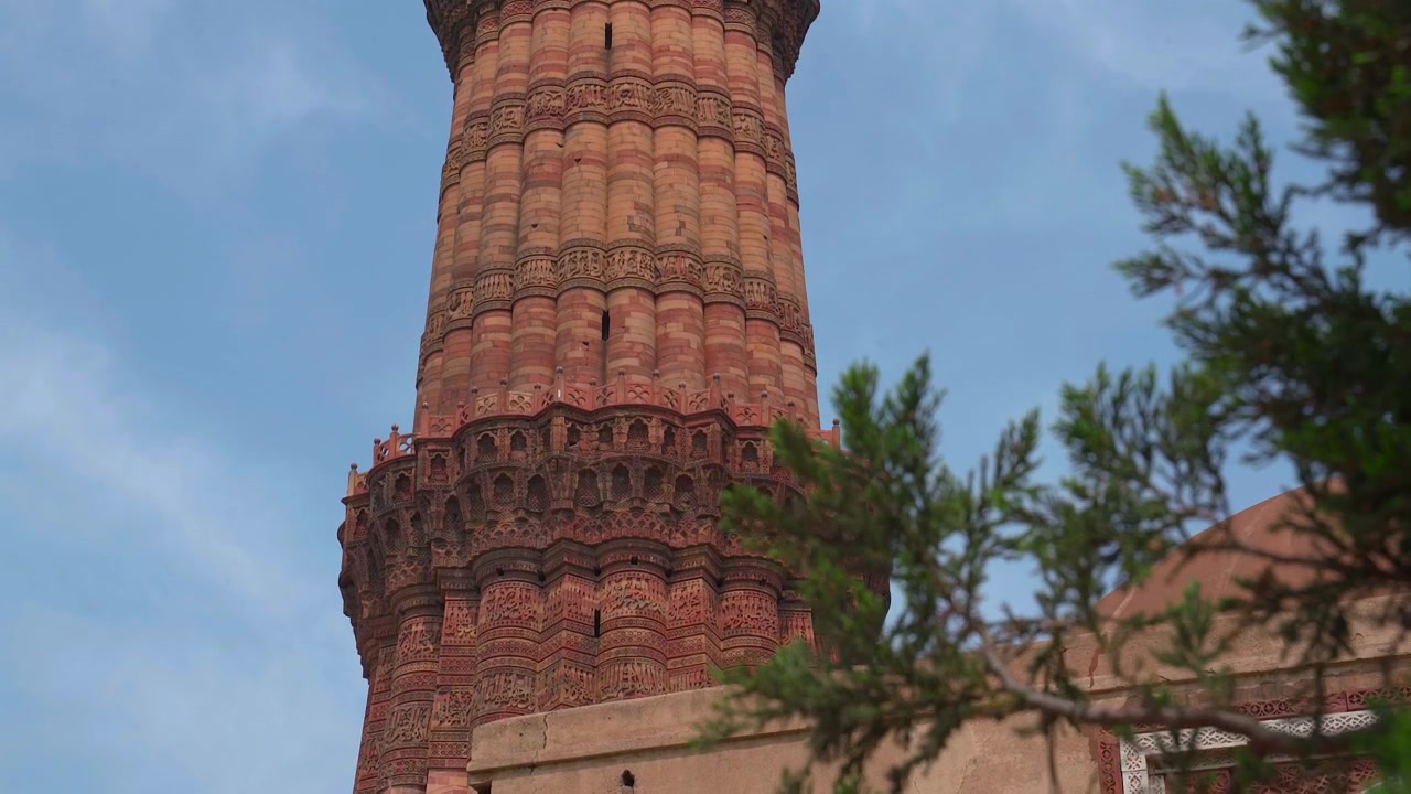 Statisk nærbillede af balkondetaljerne, indviklede udskæringer og den røde sandstenstekstur på Qutub Minar-tårnet i New Delhi, Indien.
