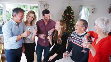 Porträt-Von-älteren-Eltern-Mit-Erwachsenen-Sprösslingen-Und-Freunden,-Die-Champagner-Trinken,-Während-Sie-Zu-Hause-Gemeinsam-Weihnachten-Feiern