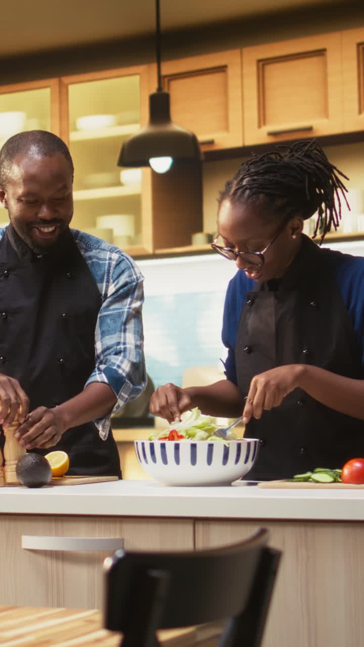 Video verticale: uomo afroamericano che condisce l'insalata con un mix di spezie e pepe