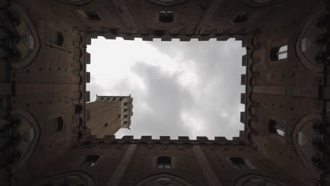 Lapso-De-Tiempo-Duomo-Siena,-Toscana-Italia,-Mirando-Hacia-Arriba-Con-Decoración-Medieval-Que-Enmarca-El-Antiguo-Campanario-Y-Las-Nubes-Pasaron