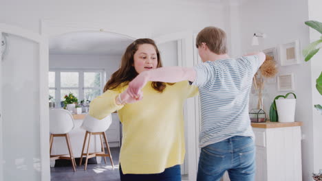 young downs syndrome couple having fun dancing at home together