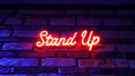 neon sign displaying stand up on a brick wall is turning on and off, creating a captivating visual effect