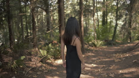 attractive black hair asian woman smiling and turn around as walking in forest, slowmo