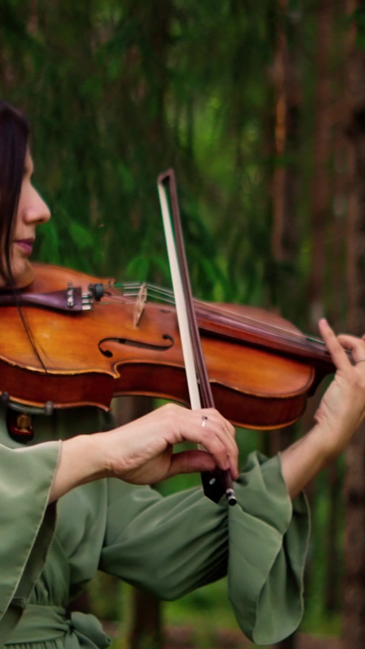 Young Woman Playing Violin in a Forest
