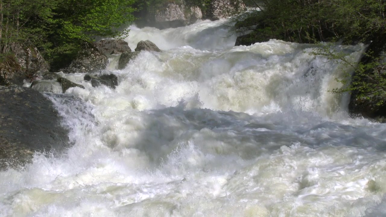 Eau de rivière puissante et impétueuse coulant sur des rochers