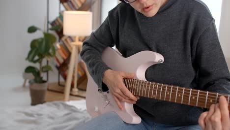 woman playing a pink electric guitar