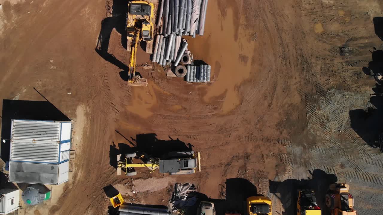 Aerial top down view of a heavy machinery parking near highway construction site