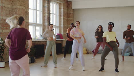 female teacher and students dancing and high fiving at class