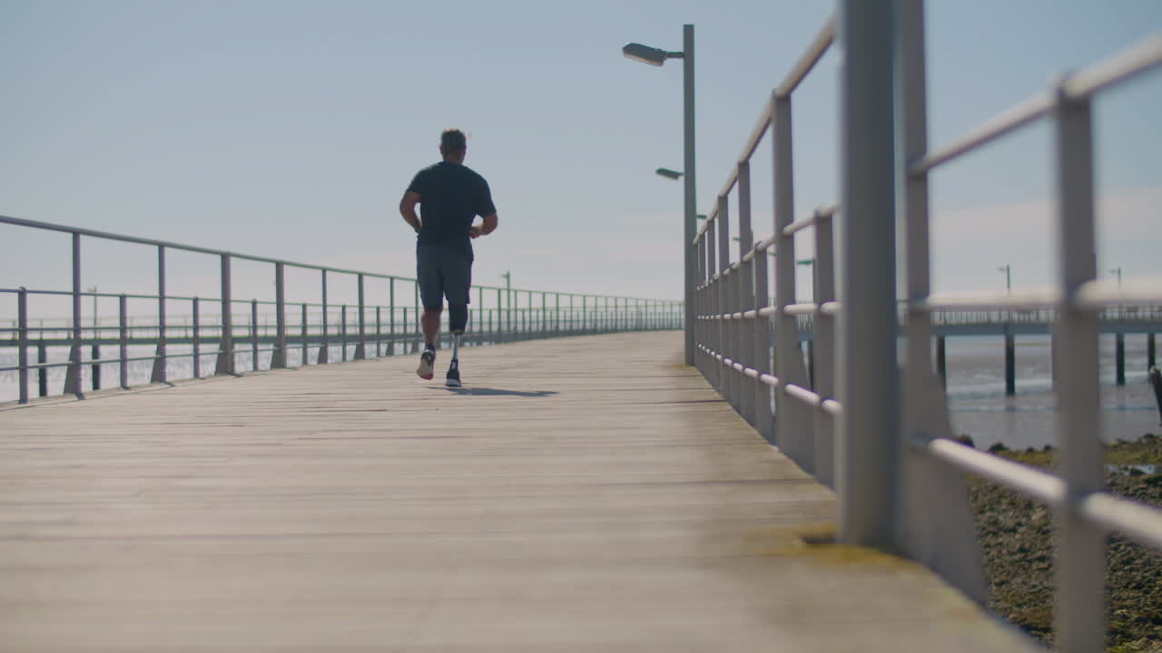 hombre fuerte con una pierna artificial corriendo en el puente.