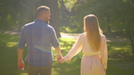 couple walking hand in hand in a park