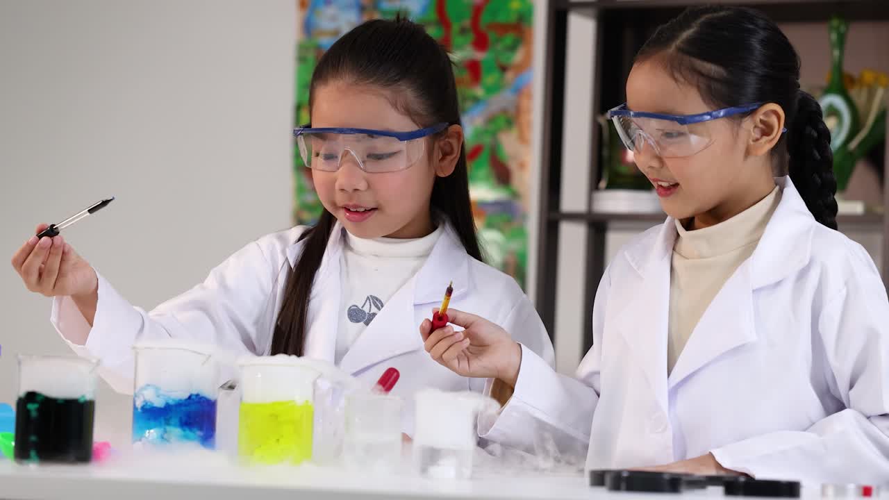 Kaksi nuorta tyttöä tekee värikkään tiedekokeen laboratoriossa