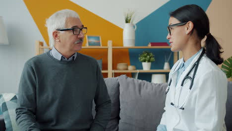 doctor consults with elderly patient at home