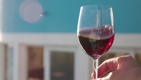 Hand-holds-and-rotates-red-wine-into-glass