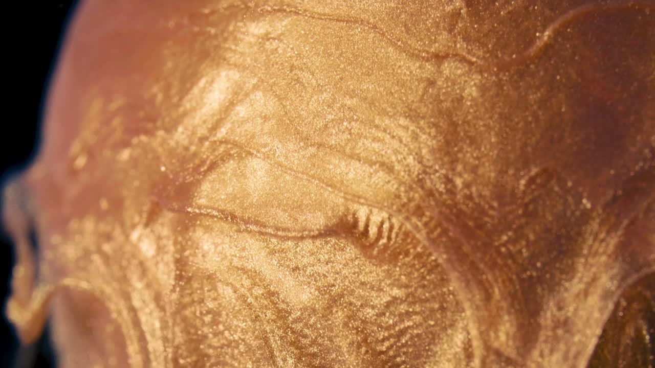 황금색 잉크 입자가 물 속으로 흐르는 것은 당근에 있는 카라멜처럼