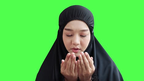 50p frame rate footage of young muslim women praying for the blessing of allah on green screen background.